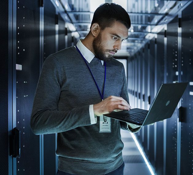 An IT technician working in a server room.
