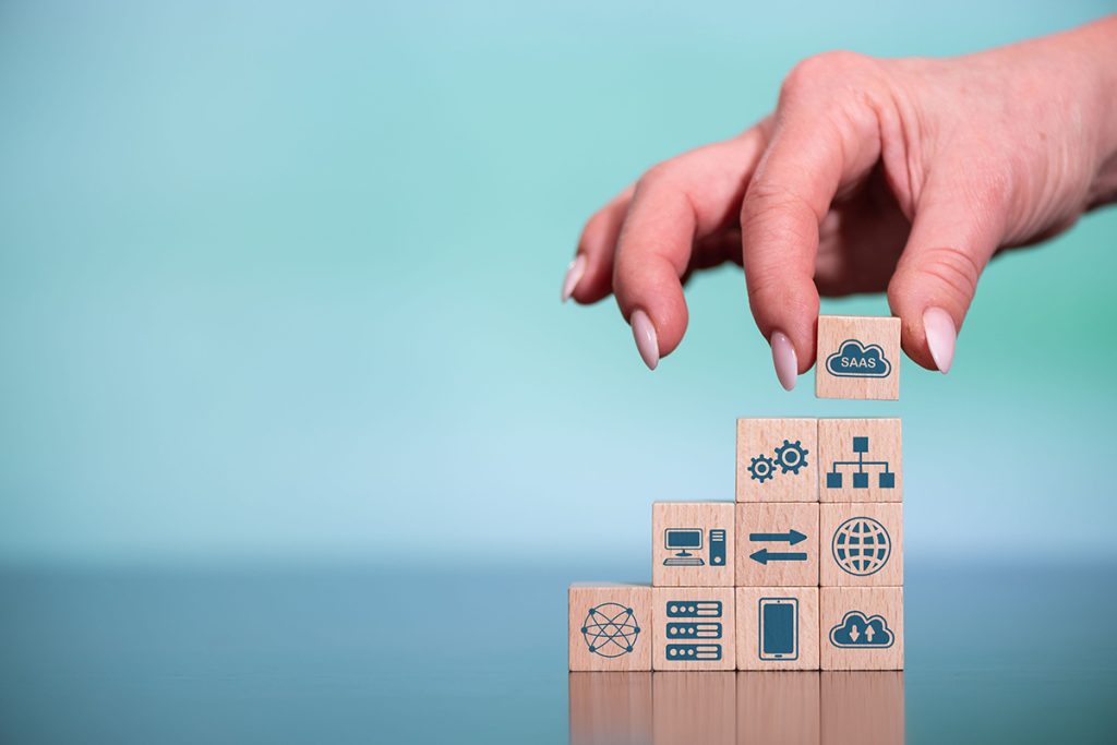 Wooden blocks stacked on each other, with images related to SaaS painted on their faces
