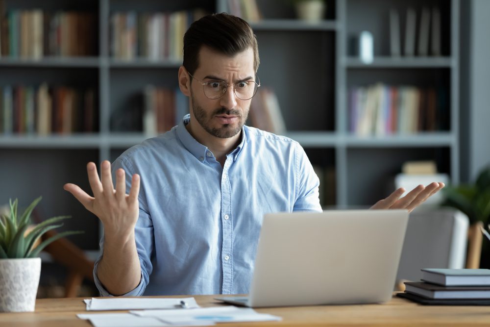 Unhappy,Young,Caucasian,Male,Worker,In,Glasses,Look,At,Laptop