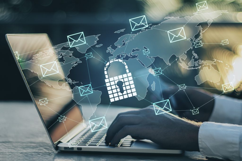 A person typing on a laptop with an email-concept image overlay.