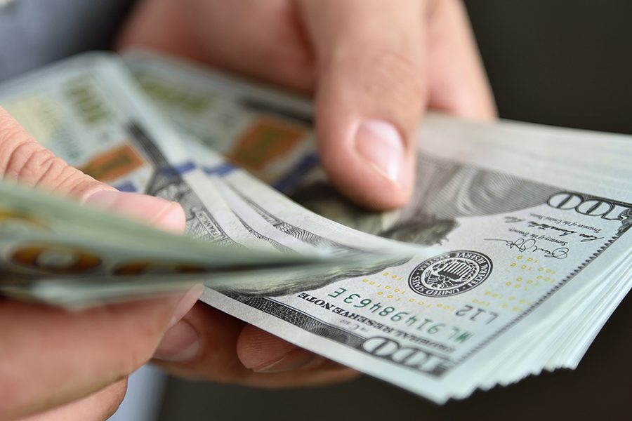 a businessman counting money to pay for fines